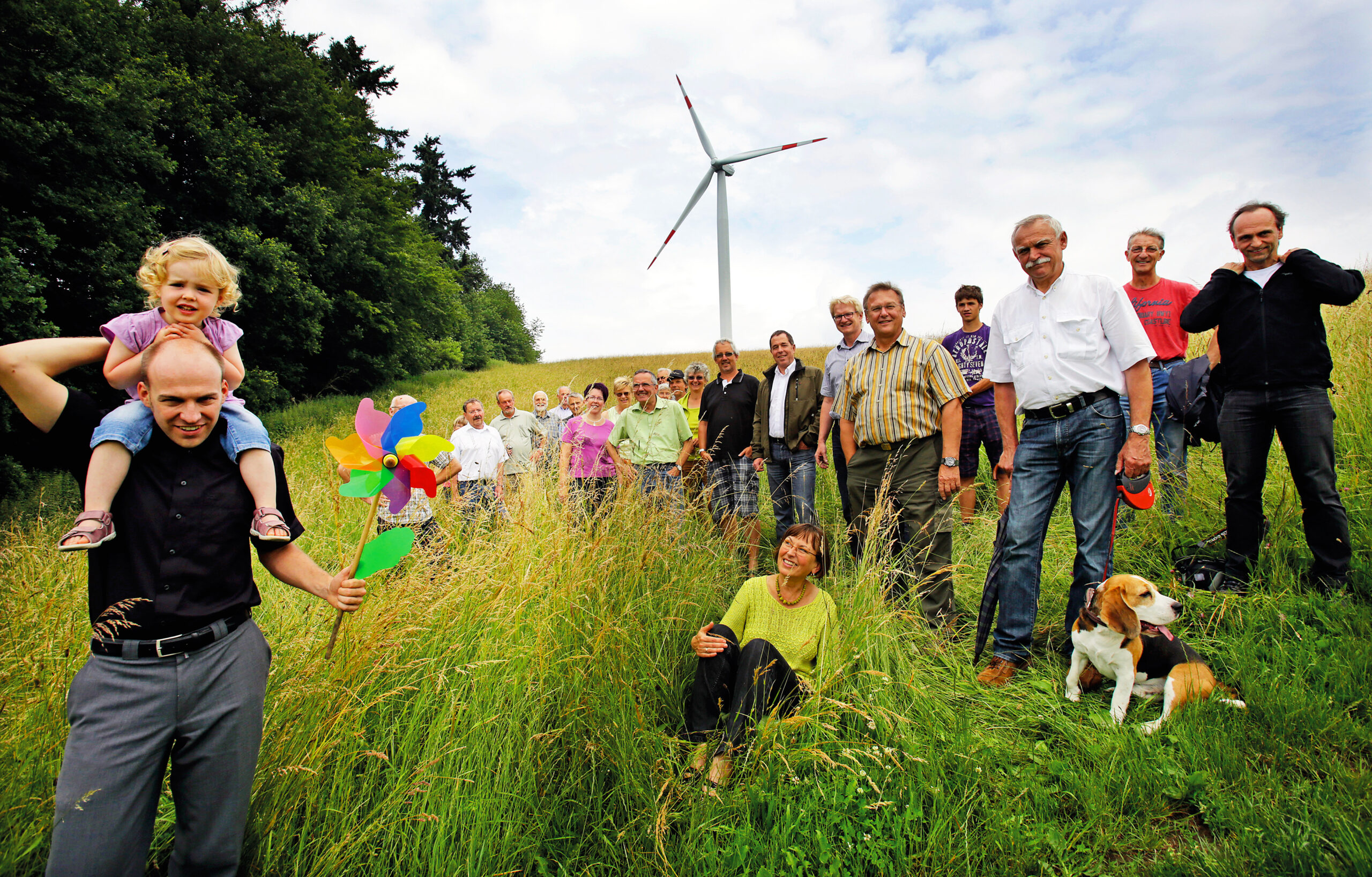 Menschen vor einem Windrad beim Odenwald